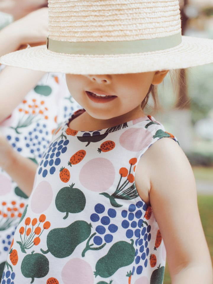 Young girl in a sun hat and a colorful printed dress